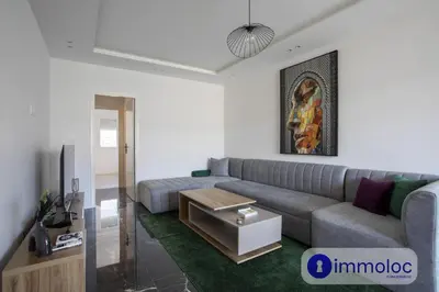 a living room with a couch and a table at Air-conditioned apartment in the Carras district close to the sea in Nice