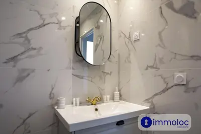 a white bathroom with a sink and a mirror at Air-conditioned apartment in the Carras district close to the sea in Nice
