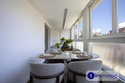 a dining room with a table and chairs and windows at Air-conditioned apartment in the Carras district close to the sea in Nice