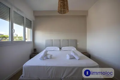 a bedroom with a large white bed with two pillows at Air-conditioned apartment in the Carras district close to the sea in Nice