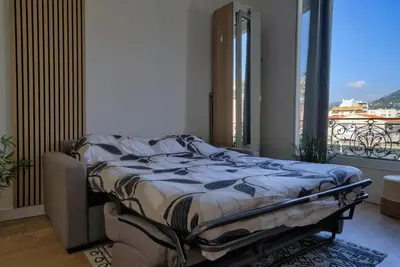 a bed in a room with a large window at Nissa la bella in Nice