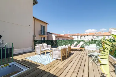 a wooden deck with chairs and a table on a building at Wide Open Sky Terrace 1 Bdr in Nice