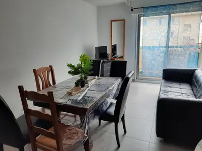 a dining room with a table and chairs and a couch at Appartement 3 chambres spacieux prés des plages à Nice in Nice
