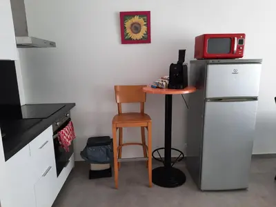 a small kitchen with a small table and a refrigerator at Appartement 3 chambres spacieux prés des plages à Nice in Nice