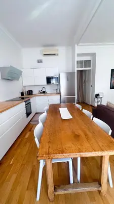 a wooden table in a living room with a kitchen at L'appart in Nice