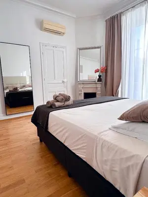 a bedroom with a large bed and a mirror at L'appart in Nice