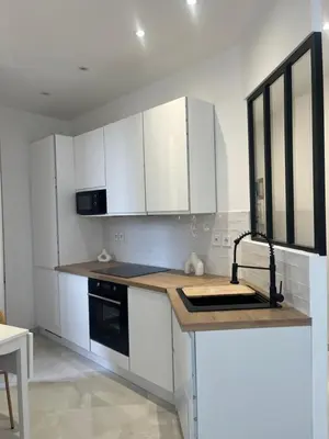 a kitchen with white cabinets and a counter top at Havre de Paix à Nice in Nice