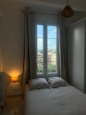 a bedroom with a bed and a large window at Havre de Paix à Nice in Nice