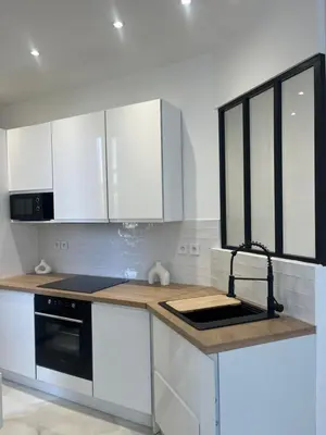 a kitchen with white cabinets and a black stove at Havre de Paix à Nice in Nice