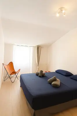 a bedroom with a blue bed and a chair at Magnifique appartement Carré Or in Nice