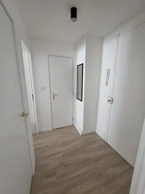 an empty hallway with white walls and wooden floors at Magnifique appartement Carré Or in Nice