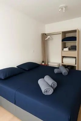 a bedroom with a blue bed with two pillows at Magnifique appartement Carré Or in Nice