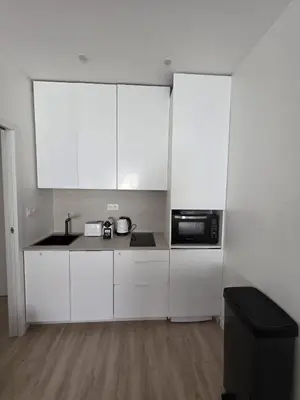 a kitchen with white cabinets and a microwave at Magnifique appartement Carré Or in Nice