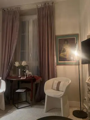 a room with a chair and a table and a lamp at Rossetti in Nice