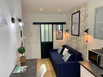 a living room with a blue couch and a kitchen at Magnifique studio Centre-ville in Nice