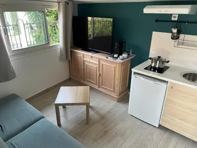 a kitchen with a couch and a tv on a counter at Studio du Domaine du Piol in Nice