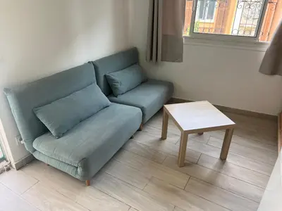 a living room with a couch and a table at Studio du Domaine du Piol in Nice