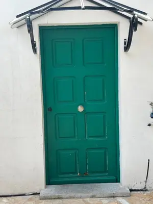 a green door on the side of a building at Studio du Domaine du Piol in Nice
