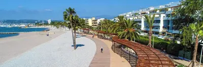 a view of a beach with palm trees and buildings at Seaside View Saint-Laurent in Saint-Laurent-du-Var