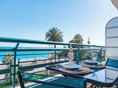 a table and chairs on a balcony with a view of the ocean at Studio Le Savoy Promenade des Anglais-5 by Interhome in Nice