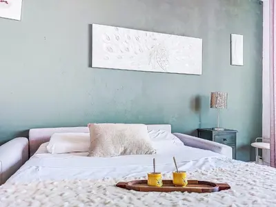 a bedroom with a bed with two yellow cups on it at Studio Le Savoy Promenade des Anglais-5 by Interhome in Nice