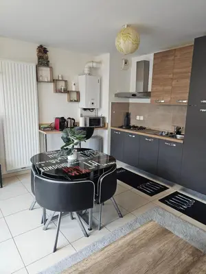 a kitchen with a table and chairs in a room at Résidence le vernier in Nice