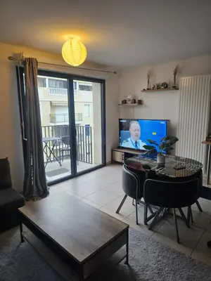 a living room with a table and a tv at Résidence le vernier in Nice
