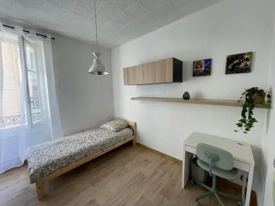 a bedroom with a bed and a desk and a window at Studio au coeur de Nice in Nice