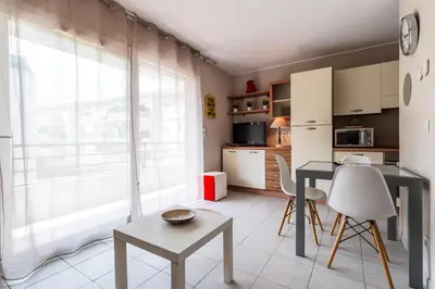 a kitchen with a table and chairs in a room at Studio cœur de ville et au calme in Cagnes-sur-Mer