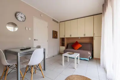 a living room with a bed and a table and chairs at Studio cœur de ville et au calme in Cagnes-sur-Mer