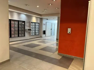 a lobby with a red wall and a tile floor at Studio cœur de ville et au calme in Cagnes-sur-Mer