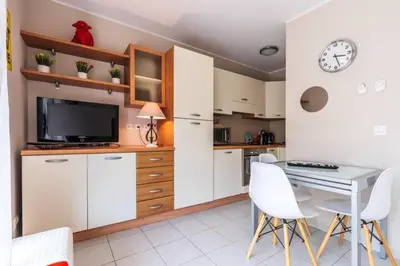 a kitchen with a table and a clock on the wall at Studio cœur de ville et au calme in Cagnes-sur-Mer