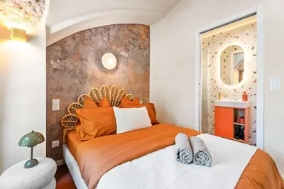 a bedroom with a large bed with an orange bedspread at Nice Renting - CROTTIb - Studio Rare Pearl Typical Chic Massena & Sea in Nice