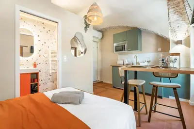 a bedroom with an orange bed and a kitchen at Nice Renting - CROTTIb - Studio Rare Pearl Typical Chic Massena & Sea in Nice