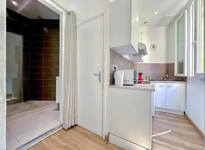 a white kitchen with a shower and a sink at Libération - Centre - Charmant Studio Balcon Clim in Nice