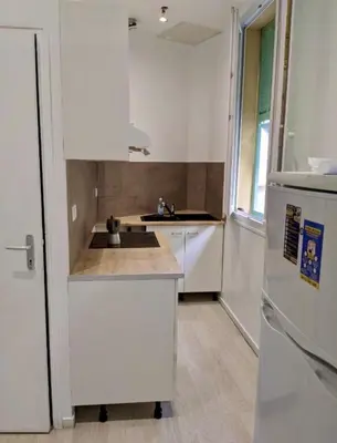 a white kitchen with a sink and a refrigerator at Libération - Centre - Charmant Studio Balcon Clim in Nice