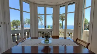 a dining room with a table with a vase of flowers at Belle Epoque Azur Promenade Nice in Nice
