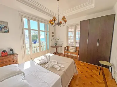 a bedroom with a large bed and a chandelier at Belle Epoque Azur Promenade Nice in Nice