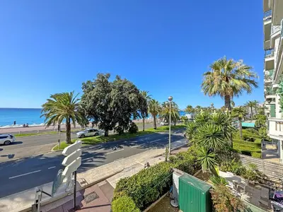 a view of a street with palm trees and the ocean at Belle Epoque Azur Promenade Nice in Nice