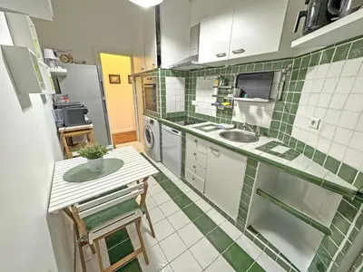 a small kitchen with green and white tiles on the wall at Belle Epoque Azur Promenade Nice in Nice