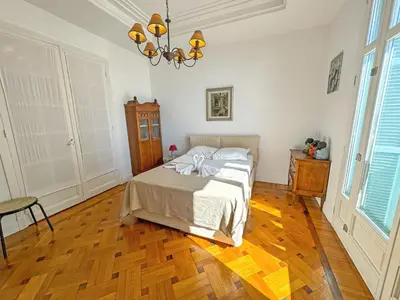 a bedroom with a bed and a chandelier at Belle Epoque Azur Promenade Nice in Nice
