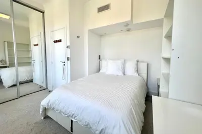 a white bedroom with a large bed and a mirror at Villa La Mascotte in Beaulieu-sur-Mer