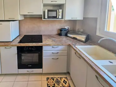 a kitchen with a stove top oven next to a sink at Beau 2 pieces avec vue imprenable sur la rade in Villefranche-sur-Mer