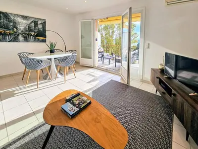 a living room with a coffee table and a tv at Beau 2 pieces avec vue imprenable sur la rade in Villefranche-sur-Mer