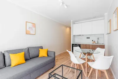 a living room with a couch and a table and chairs at Grand studio 4 couchages quartier Musiciens in Nice