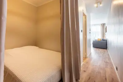 a bedroom with a bed and a hallway with a couch at Grand studio 4 couchages quartier Musiciens in Nice