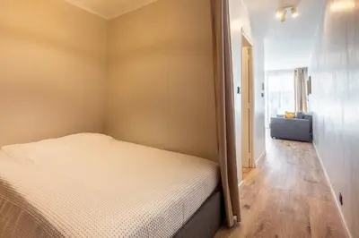 a small bedroom with a bed and a hallway at Grand studio 4 couchages quartier Musiciens in Nice