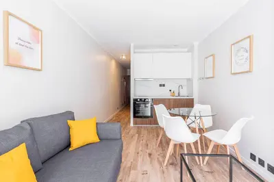 a living room with a gray couch and white chairs at Grand studio 4 couchages quartier Musiciens in Nice