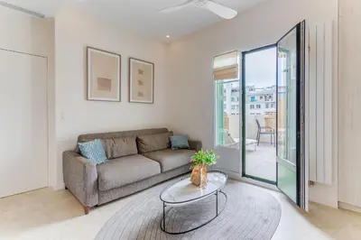 a living room with a couch and a glass table at COCO BEACH AP4476 by Riviera Holiday Homes in Nice