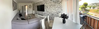 a living room with a couch and a tv on a brick wall at Nice vauban in Nice